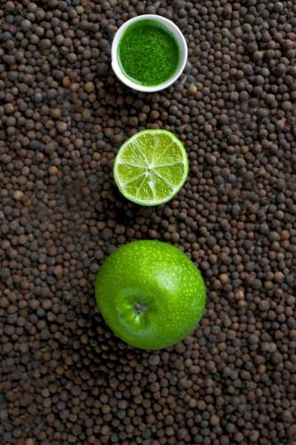 a green apple and a lime and a bowl of green liquid at Green Vilnius Hotel in Vilnius