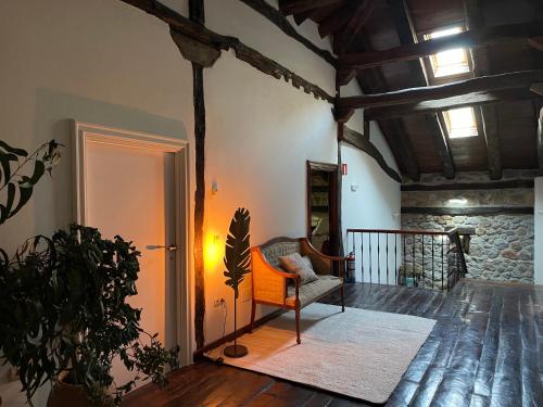 a living room with a chair and a stone wall at El Jardin de las Magnolias Hotel in Quintana de Soba