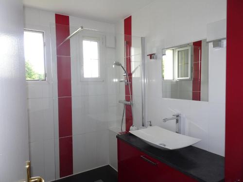 La salle de bains est pourvue d'un lavabo et d'un mur rouge et blanc. dans l'établissement Holiday Home in Guerlesquin near Lake, à Guerlesquin
