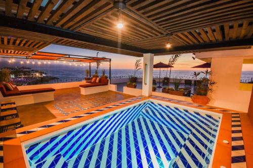 a pool in a room with a view of the ocean at Condominio Oceano Oro in Puerto Vallarta