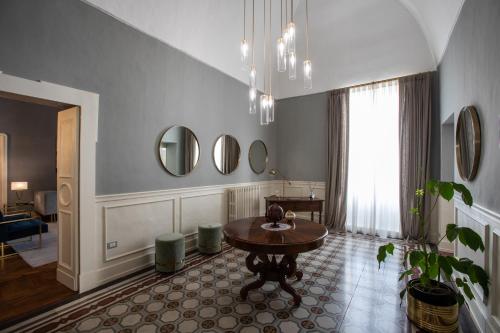 ein Wohnzimmer mit einem Tisch und einem Fenster in der Unterkunft Palazzo Sansonetti in Casarano