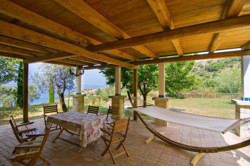 a porch with a hammock and a table and chairs at Into lupene in Acciaroli