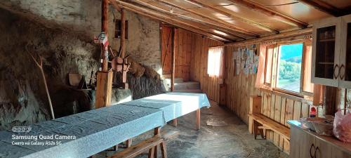 una habitación con una mesa larga en una sala de trenes en Guest House Tsasne en Omalo