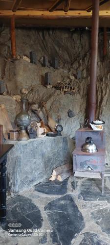 a room with a stone wall with pots and pans at Guest House Tsasne in Omalo