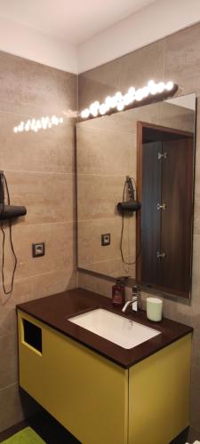 uma casa de banho com um lavatório e um espelho grande em Suite Camões no Porto