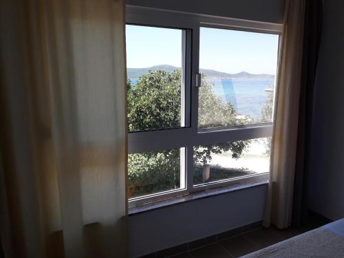 a bedroom window with a view of the ocean at Crancina in Sveti Filip i Jakov