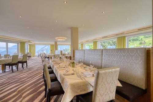 a dining room with a long table and chairs at Alpinresort Schillerkopf in Bürserberg