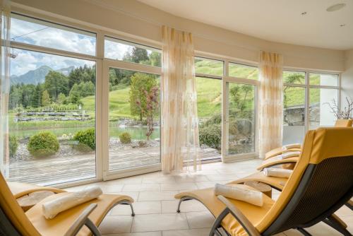 a waiting room with chairs and large windows at Alpinresort Schillerkopf in Bürserberg