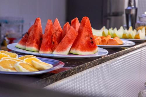 a bunch of plates of watermelon and oranges on a counter at Pousada Castelinho in São Sebastião