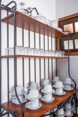 a shelf with cups and dishes on it at Pousada Castelinho in São Sebastião