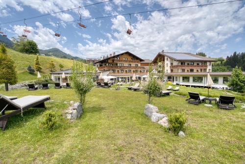 a resort in the mountains with tables and chairs at Alpinresort Schillerkopf in Bürserberg