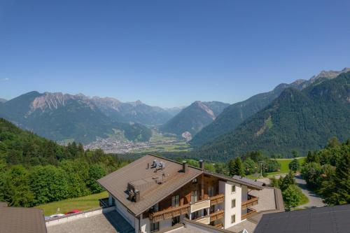 a view of a building with mountains in the background at Alpinresort Schillerkopf in Bürserberg