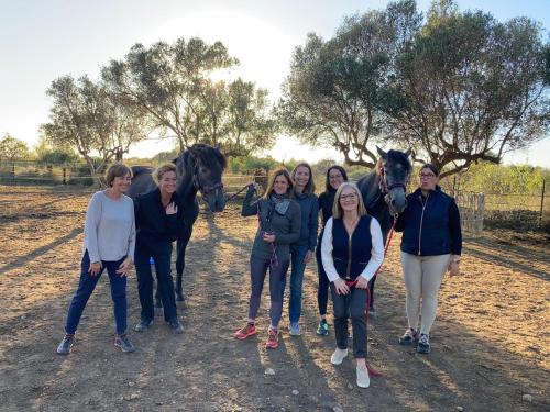 a group of people standing in front of two horses at El Jardin de las Magnolias Hotel in Quintana de Soba