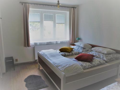 a bedroom with a bed with pillows and a window at Resort LUFT Sněžník in Sněžnik