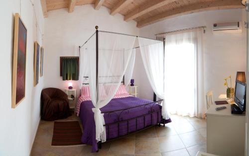1 dormitorio con 1 cama con dosel en Case Giannone, en Santa Flavia