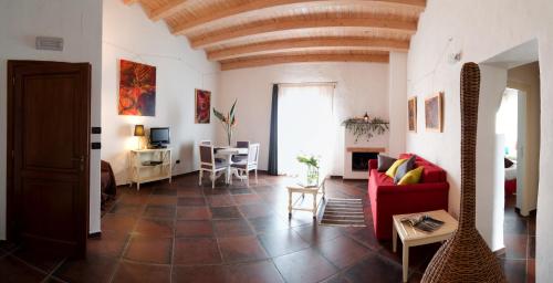 sala de estar con sofá rojo y mesa en Case Giannone, en Santa Flavia