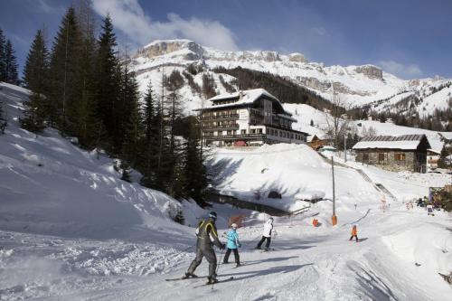 a group of people skiing down a snow covered mountain at Sporthotel Arabba in Arabba