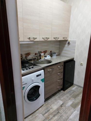 a kitchen with a washing machine and a sink at Кобулети Residence двухспални Апартаменты Gio in K'obulet'i