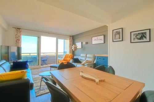 un salon avec une table en bois et une chambre avec vue dans l'établissement La Douce Vie, à Le Touquet-Paris-Plage