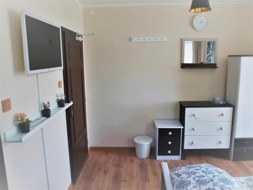 a bedroom with a bed and a dresser and a tv at Resort LUFT Sněžník in Sněžnik