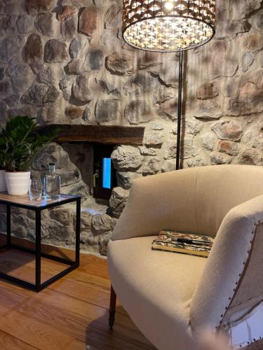 a living room with a couch and a stone wall at El Jardin de las Magnolias Hotel in Quintana de Soba