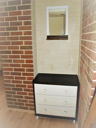 a dresser with a mirror and a brick wall at Resort LUFT Sněžník in Sněžnik
