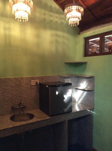 a bathroom with a sink and a tv on a counter at Maharaju Palace in Kovalam