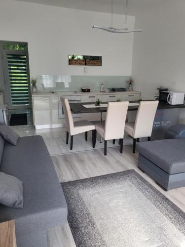a living room with a couch and a table and chairs at Freedom apartman in Zamárdi