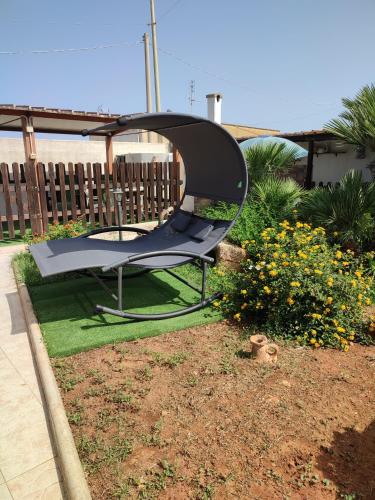a hammock sitting in a yard next to some flowers at Le Due Palme in Marsala