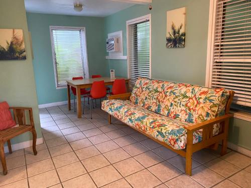 uma sala de estar com um sofá e uma mesa em Alexander Palms Court - No Hidden Resort Fees! em Key West