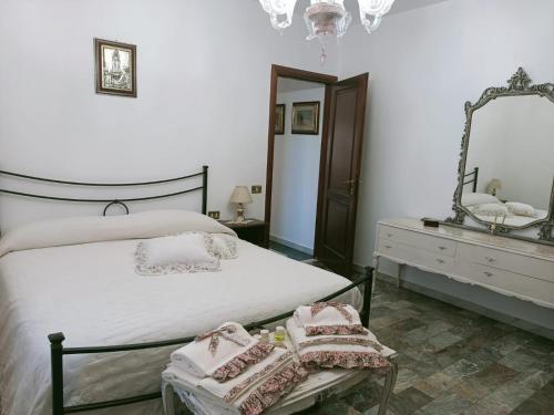 um quarto com uma cama branca e um espelho em Pirro & Sharon House em Pianore