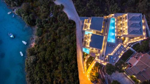 Sivota Deamaris Luxury Boutique Hotel في سيفوتا: اطلالة علوية على منتجع به مسبح في الليل