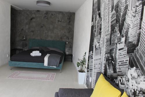 een slaapkamer met een bed en een muur met posters bij Apartmány Stříbro in Stříbro