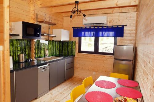 a kitchen with a table and chairs in a cabin at DOMEK Z SAUNĄ i JACUZZI NAD JEZIOREM BORY TUCHOLSKIE in Błądzin