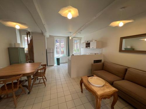 un salon avec un canapé et une table dans l'établissement Chez Mauricette, à Saint-Valery-en-Caux