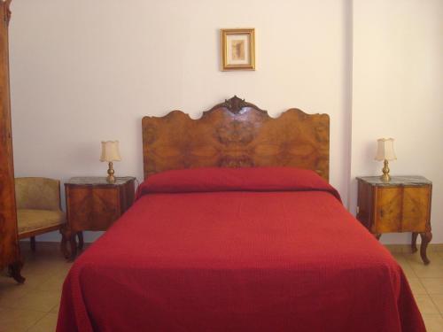 a bedroom with a bed with a red bedspread at Attico Con Vista Panoramica Sul Mare in Sciacca