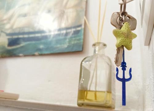 a bottle on a shelf with a star keychain at Le notti di Nettuno a Isola Delle Femmine in Isola delle Femmine