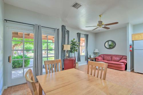 a living room with a table and a red couch at Tranquil Eloy Apartment with Oasis Courtyard! in Eloy