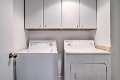 a laundry room with white cabinets and a washer and dryer at Beautiful Condo with Balcony on Lake Chelan! in Chelan