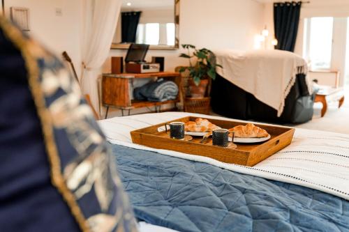 a tray of food on top of a bed at Spacious Sea-View Apt. Overlooking St Ives Bay in Gwithian