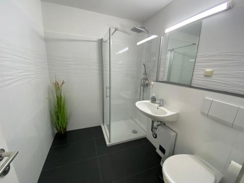 ein Bad mit einer Dusche, einem WC und einem Waschbecken in der Unterkunft Haus Südstrand, Scharbeutz-Sierksdorf in Sierksdorf
