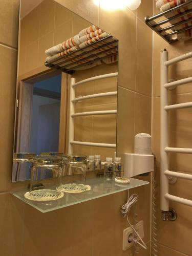 a bathroom with a shelf with glasses and a mirror at Vila Claudia in Palanga