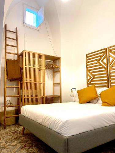 a bedroom with a bed with yellow pillows and a ladder at Casa Stella Salento - grazioso appartamento con 2 camere da letto nel cuore di Galatone in Galatone