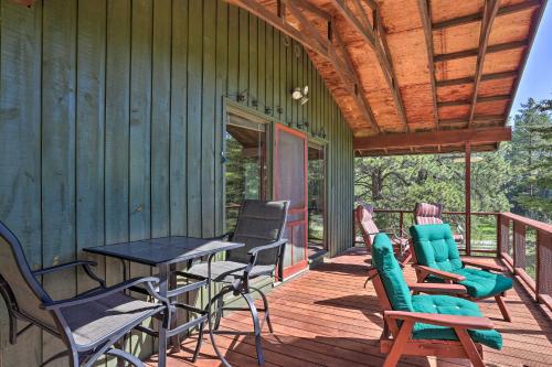 a wooden deck with chairs and a table on a house at Creekside Rapid City Cabin with Deck on 30 Acres! in Rapid City