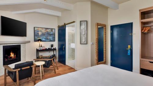 a bedroom with a bed and a desk and a fireplace at Inn At Rose's Landing in Morro Bay