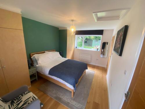 um quarto com uma cama e uma parede verde em Self-contained, ground floor apartment with parking and patio em Walmer