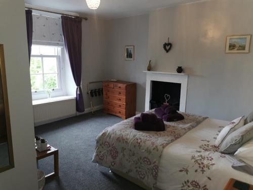 a bedroom with a bed with purple pillows on it at Rainors farm B&B in Gosforth