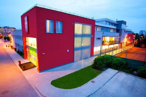 a red building on a street with buildings at Hotel EMPIRE in Trnava