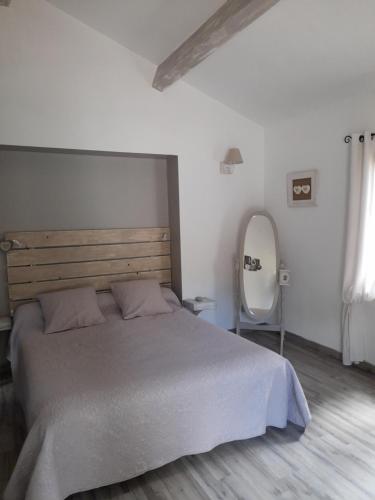 1 dormitorio con 1 cama grande y espejo en Chambre d'hote, en Le Beausset