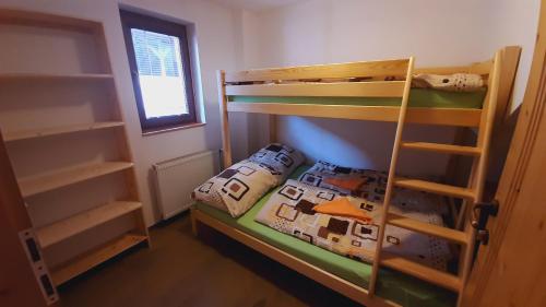 a bedroom with two bunk beds and a ladder at Chata Kriváň - bez kontaktu s ubytovateľom "Click 'n Sleep" in Terchová